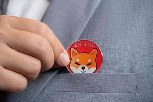 Focus select and blur Foreground Shiba coin SHIB included with Cryptocurrency hand picked in suit bag business man or bank employees wearing a gray suit. Filed and put and give to me. photo