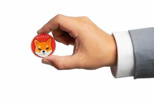 Hand or fingers picking Shiba coin group included Crypto currency on hand business man in gray suit. Filed and put and give to me isolated on white background photo