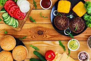 Ingredients for burger on wooden background. Top view photo