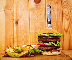 Delicious handmade burger on wooden background. Close view photo