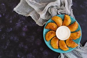 Baked dumplings on dark background. Top view photo