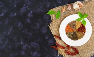 Different spices on dark background. Top view photo