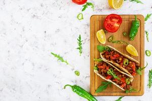 Mexican tacos with beef in tomato sauce photo