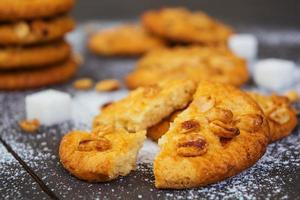 Cookies with peanuts on dark wooden background photo