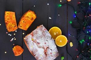 Cupcake with orange and dried apricots on Christmas background photo