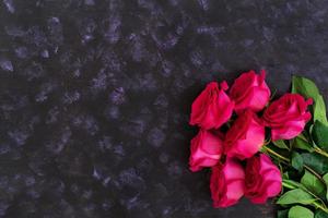 Bouquet of pink roses on dark background. Top view photo