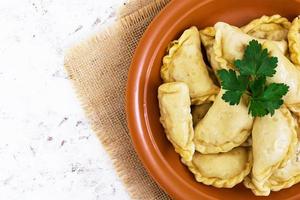 Delicious dumplings with cabbage on white background. Top view photo