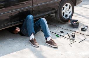 The car mechanic is under the car. photo