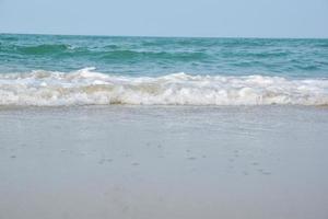 Wide angle shot of sea water hitting the beach, white sponge of the sea, summer nature background image concept. photo