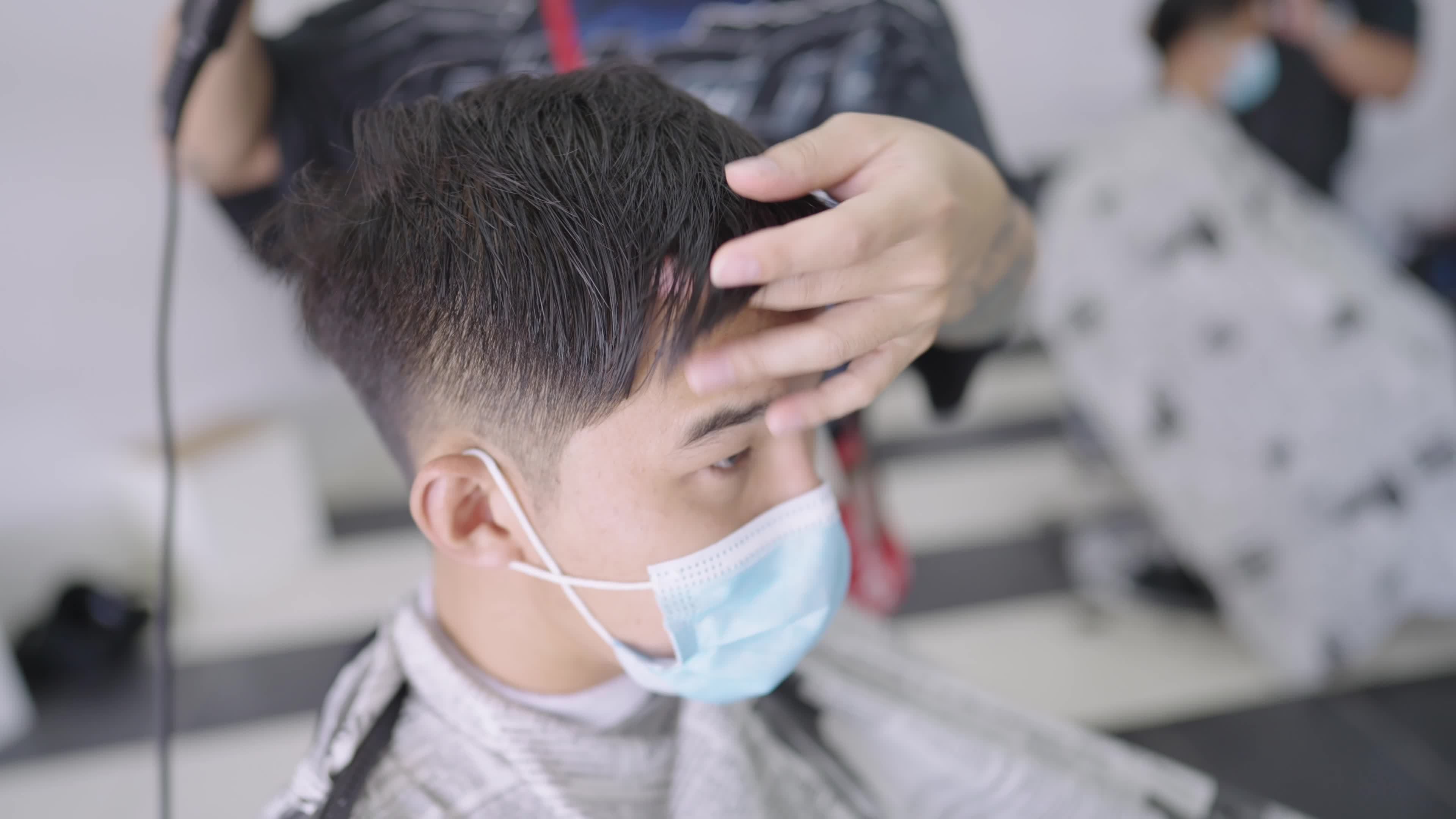 Asian man wear protective mask getting a hair cut during pandemic,  reopening business, professional hairdresser drying client's hairs after  cutting service, grooming check, new normal adaptation 7300740 Stock Video  at Vecteezy