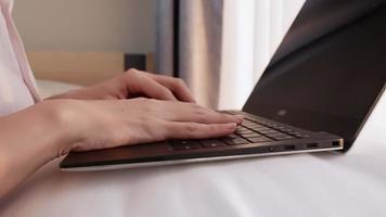 Close up female worker typing on laptop computer keyboard, work from home concept, hard working lady, answering email writing papers or plan on the computer software, workaholic place laptop on pillow video