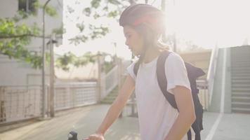 Young mixed race blonde girl being taught to ride a bicycle at green park, memorable moment of first time doing, sporty female student in helmet practicing cycling, using bicycle commutes, video
