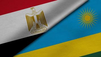 Representación 3d de dos banderas de la república árabe de egipto y la república de ruanda junto con textura de tela, relaciones bilaterales, paz y conflicto entre países, genial para el fondo foto