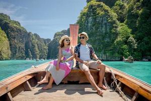 mujer y hombre sentados en la proa del barco llegan al mar, phuket, tailandia. foto