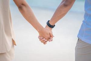 Hands of a woman and a man walking by the sea photo