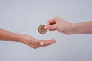 Businessman gives gold bitcoins to another woman. two hands exchanging digital currency A new world of online currency development photo