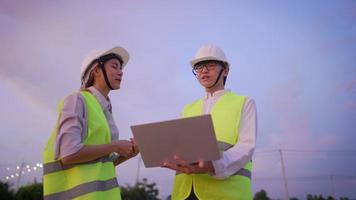 un constructor senior profesional dando una explicación de trabajo a un joven aprendiz en el sitio de construcción, feliz trabajo en equipo, joven arquitecta discutiendo sobre el posible diseño según lo requieran los clientes, video