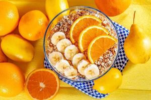 tazón de cereal con plátanos y naranjas para el desayuno sobre fondo de fruta fresca