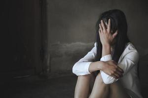 mujeres sentadas en el suelo llorando de depresión, mujer deprimida, problemas familiares, estrés, cocina, abuso, violencia doméstica, el concepto de depresión y suicidio. foto