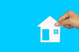 The house in human hands  on blue background, Real estate concept, Mortgage property home concept, Copy space. photo