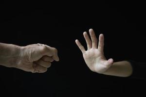 Violent young man threatening his girlfriend with his fist. Domestic violence concept, stop violence against Women. photo