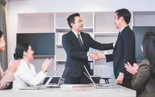 concepto de trabajo en equipo de éxito y felicidad, apretón de manos de empresario que termina una reunión de asociación comercial después de un buen trato foto