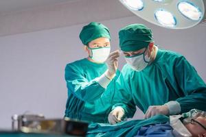 Medical team performing surgical operation in operating Room, Concentrated surgical team operating a patient photo