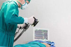 Selective focus at defibrillators while doctor pump hearts in the operating room photo