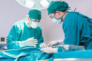 Medical team performing surgical operation in operating Room, Concentrated surgical team operating a patient photo