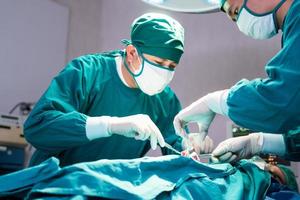 Medical team performing surgical operation in operating Room, Concentrated surgical team operating a patient photo