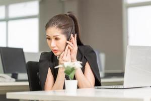 Businesswoman using phone in office. Excited pretty girl using smartphone in office, woman working in her home office