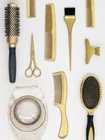 Vertical background with golden hairdresser tools. Hair salon accessories, comb, scissors on white. photo