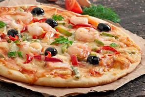 Pizza with shrimp, salmon and olives photo