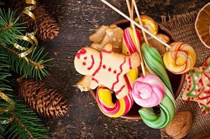 Christmas gingerbread cookies and lollipops  on old wooden background photo