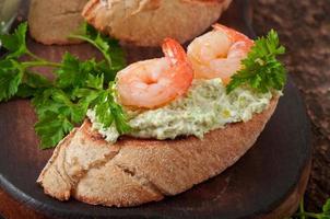 bruschetta con pasta de guisantes verdes y gambas foto