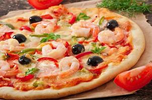 Pizza with shrimp, salmon and olives photo