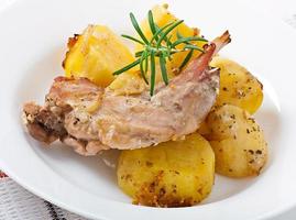 Oven Baked rabbit legs with potatoes and rosemary photo