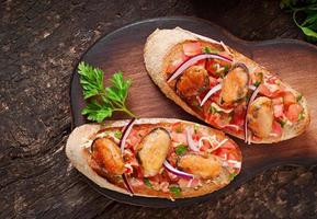 bruschetta con mejillones, queso y tomates foto