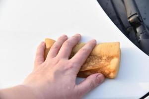 Washing a white car with a sponge by hand photo