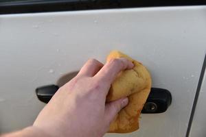 Washing a white car with a sponge by hand photo