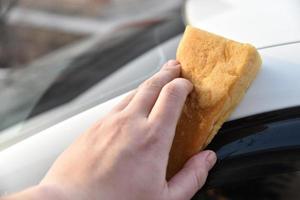 Washing a white car with a sponge by hand photo