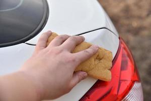 Washing a white car with a sponge by hand photo