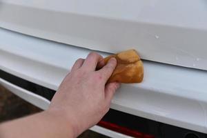 Washing a white car with a sponge by hand photo