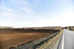 Spring arable field in the village and the horizon photo