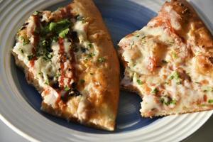 Triangular slice of pizza on a white plate photo