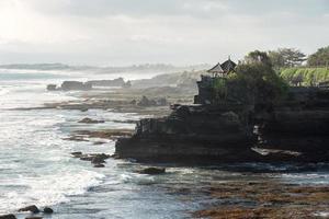 Ancient Pura Batu Bolong temple on rocky mountain at coastline photo