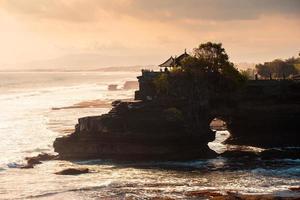 Ancient Pura Batu Bolong temple on coastline in the evening at Bali photo