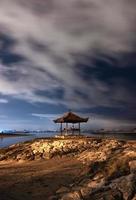Pavilion on rock jetty with cloudy in sanur beach photo