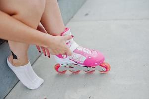 mujer joven poniéndose patines al aire libre. foto