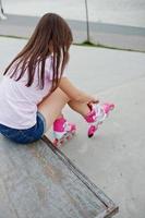 mujer joven poniéndose patines al aire libre. foto